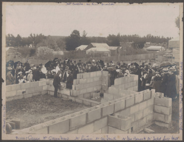 Crowd watching stone being laid.