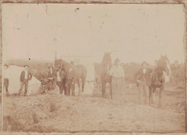 Men, horses, building at dam building site.