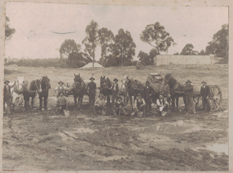 Men, horses and carts building a dam.