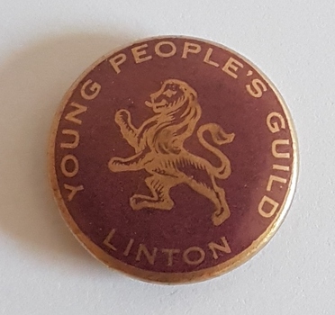 Round, brown badge with gold lion.