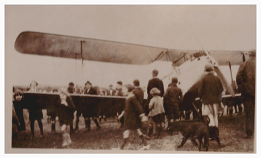 Crowd of people around a bi-plane.