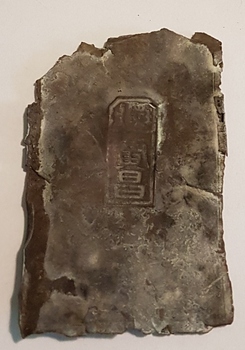 Metal fragment with Chinese characters.