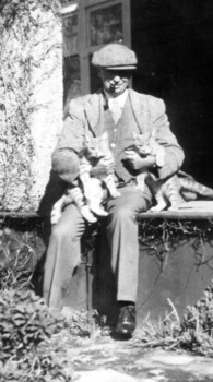 Man holding two cats.