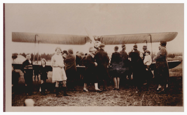 Crowd of people around a biplane.