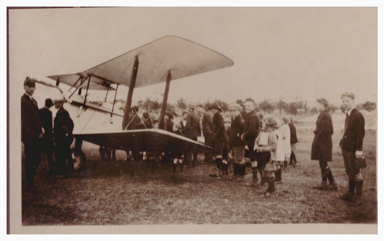 Crowd od people around a biplane.