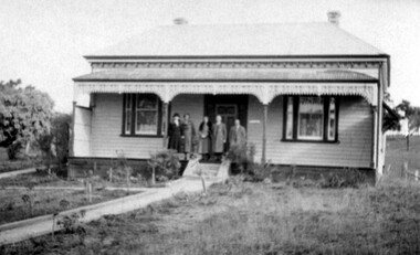 People on front verandah of a house.