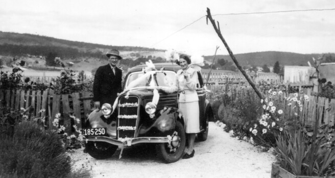 Man and woman next to a decorated car.