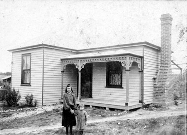 Two children outside a house.