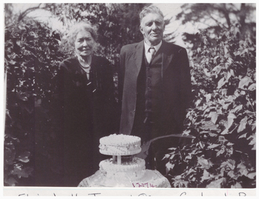 Portrait of a couple with a celebration cake.