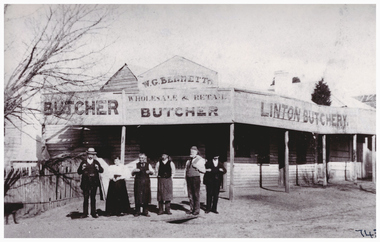 People in front of an early butcher shop.