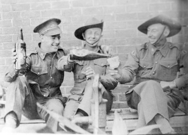 Image of three soldiers having a beer.