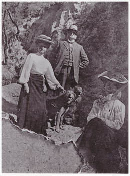 Image of three people and two dogs.