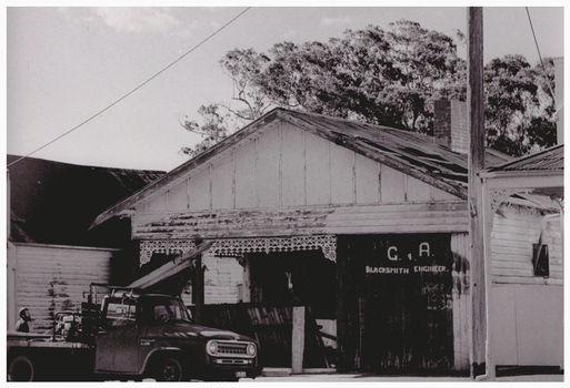 Truck in front of a dilapidated building.