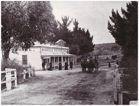 People and horses outside a hotel.