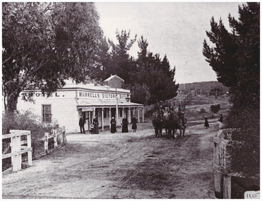 People and horses outside a hotel.