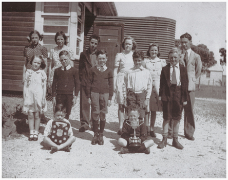 Pupils and a teacher with trophies.