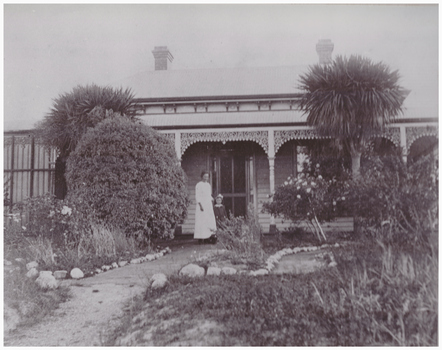 Woman and child in front of a house.