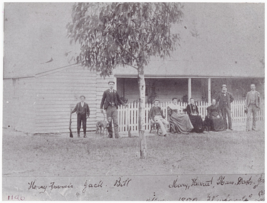 People and a dog outside a house.