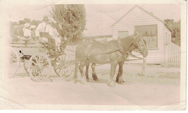 Adults and children on a horsedrawn cart.