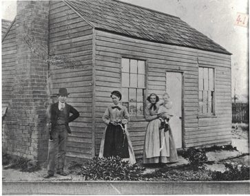 People outside an early cottage.