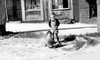 Two young boys playing in the street.