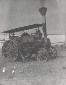 Man at wheel of a traction engine.