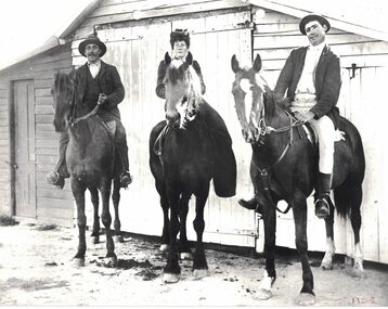 Three people riding horses.