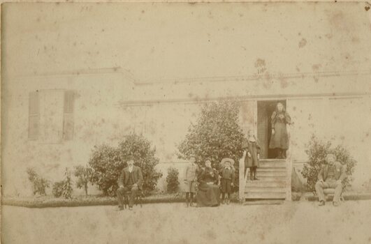 Family outside a homestead.