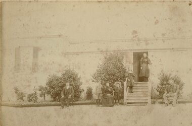 Family outside a homestead.