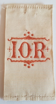 Small cream ribbon with orange embroidery.