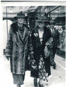 Two women walking down a street.