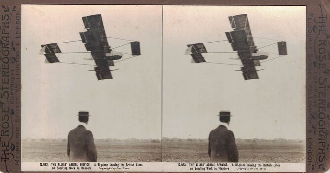 Man watching a biplane.