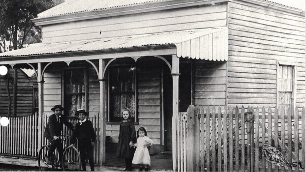 Four children in front of a house.