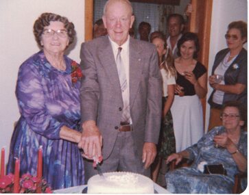Image of a couple cutting a cake.