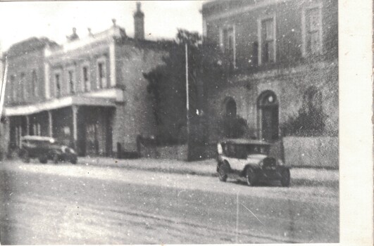 Streetscape showing buildings and cars.