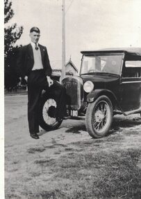 A man in front of a car.