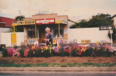 Photograph, Carrie Murrell outside Murrell's Newsagency, date unknown