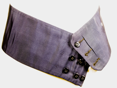 Navy blue Cummerbund showing three rows of three black buttons and button holes for fastening