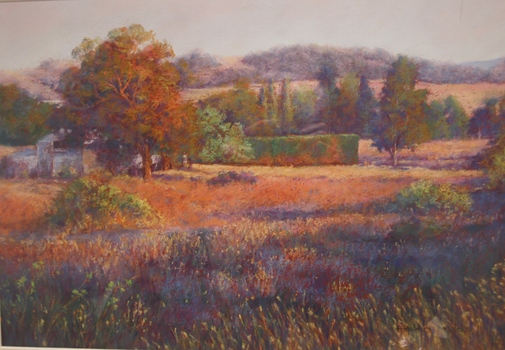Painting of a sunset on a rural field full of long grasses with a large tree to the left of the frame. Trees, hedges and hills in the background.
