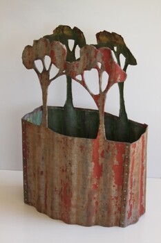 Recycled corrugaged iron sculpture of four trees on a oval shaped hollow base
