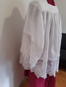 Clothing - Ecclesiastical clothing, Surplice. White linen tunic  reaching to the knees, with moderately wide sleeves.  Crocheted lace trim with  pascal lamb symbol and cross