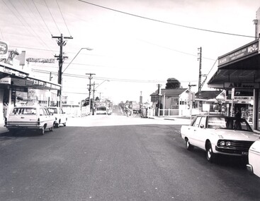 The level crossing gates at Highett are open and there is a clear view along Highett Road.