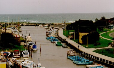 Boats moored on either side of the creek, leading down to the mouth