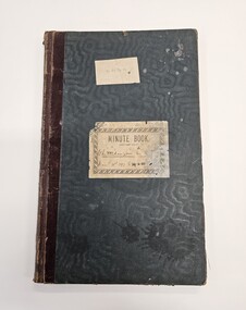 Green hard cover book with two white labels adhered to the front