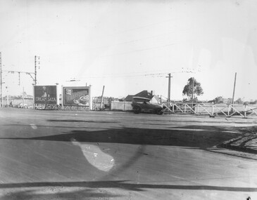A car waits at the Moorabbin level crossing for the gates to open