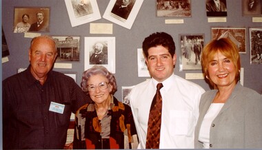 Four people lined up in front of a photo board