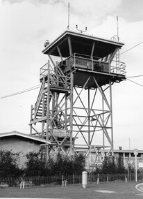 Metal tour with aerials in front of a brick, single storey building