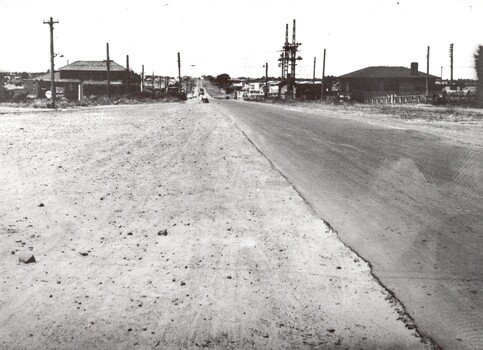 The wide gravel shoulder beside the road makes the road look wider than it is