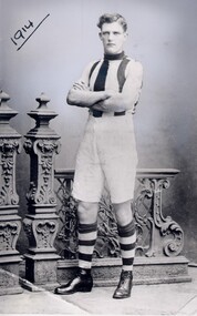 A young man in football jersey, white shorts and striped knee-high socks. The date 1914 is underlined in the top lefthand corner