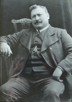 A man sitting in a high-backed chair facing the camera